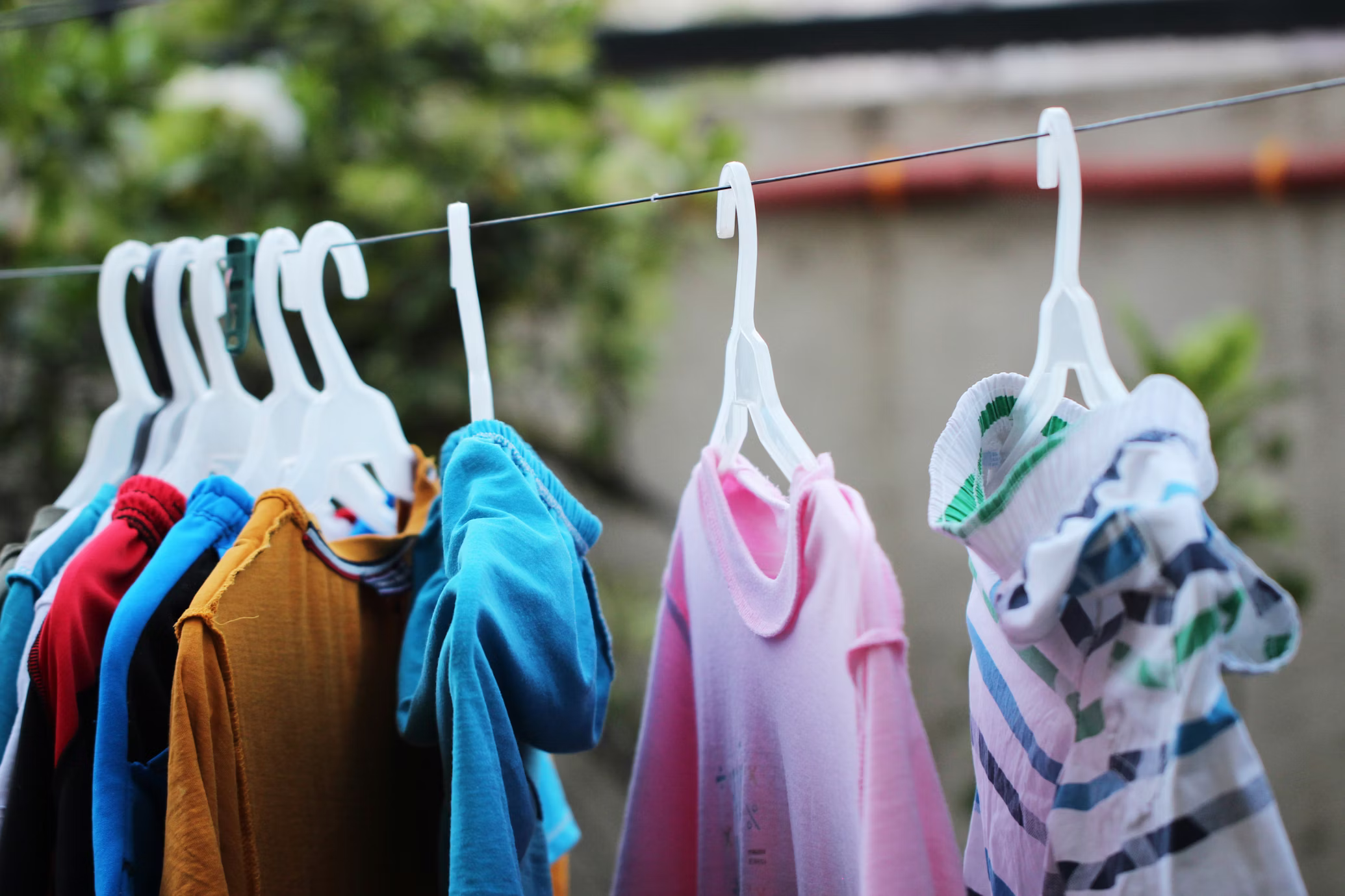 Laundry hanging on a guesthouse balcony clothesline with a tropical Philippine backdrop