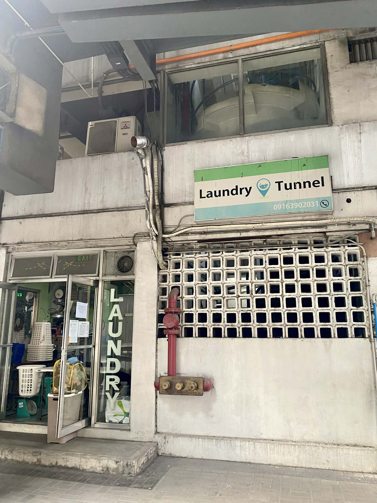 Street-level laundry shop in Southeast Asia showing a typical drop-off and self-service setup
